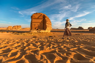 Blonde Tourist Walking In The Desert Admiring The Monumental Qasr Al Farid A Solitary Nabataean
