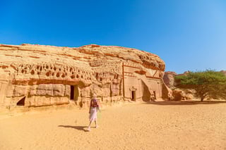 Blonde Tourist Walking In The Desert Next To Of Jabal Albanat And Giant Rock Cut Tomb Of The