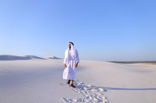 Stately Young Sheikh Walks On Foot Along Bottomless Desert Leaving Traces On Sand Enjoying Warm